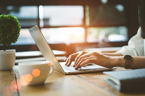 Image of hands typing on a laptop