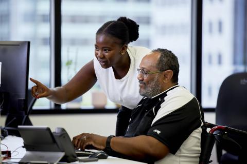 Female worker and male participant at computer